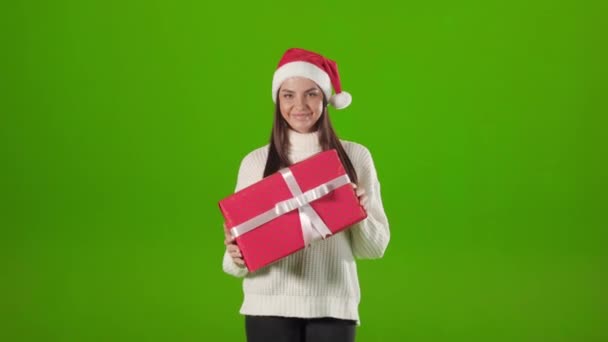 Mujer en sombrero de santa posando con navidad presente en estudio — Vídeos de Stock