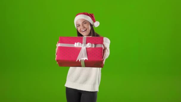 Frau überreicht Weihnachtsgeschenk auf grünem Hintergrund — Stockvideo