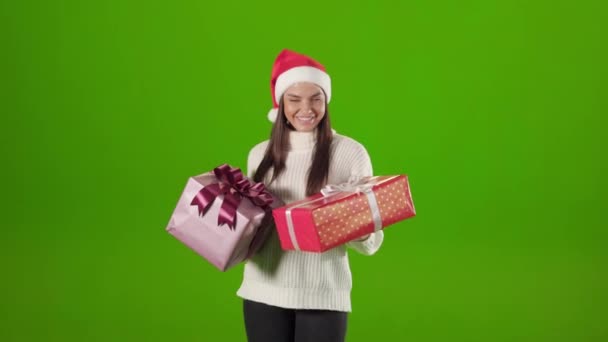 Γυναίκα με καπέλο Άη Βασίλη χορεύει με δύο κουτιά χριστουγεννιάτικο δώρο — Αρχείο Βίντεο