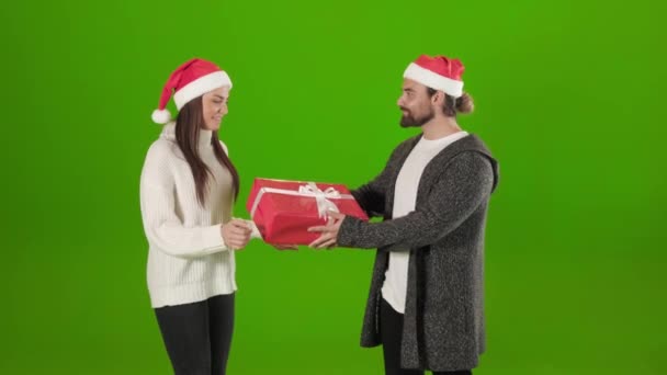 Mann mit Weihnachtsmütze schenkt seiner liebenden Frau ein Weihnachtsgeschenk — Stockvideo