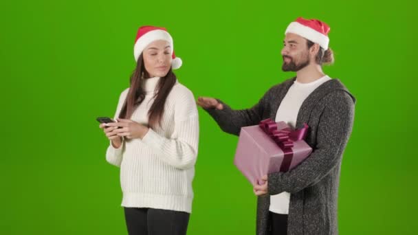 Man i tomte hatt ger julklapp till kvinna med mobil — Stockvideo