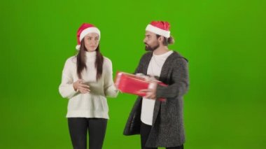 Sakallı adam bayanların elinden Noel kutusunu alıyor.