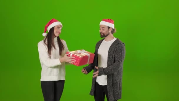 Mujer en sombrero de santa presentación de regalo de Navidad a su hombre — Vídeo de stock
