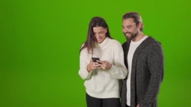 Mutlu çift modern akıllı telefondan komik bir şeyler okuyor.