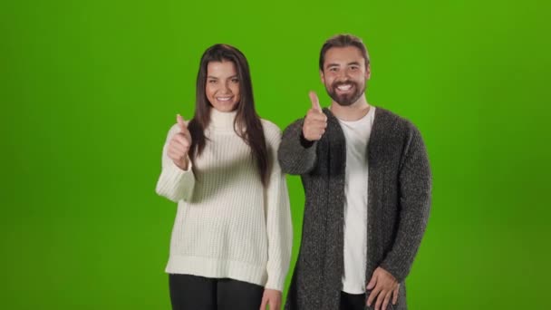 Casal feliz mostrando polegares para cima sobre fundo verde — Vídeo de Stock