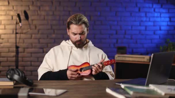 Человек чувствует разочарование во время онлайн обучения на гитаре — стоковое видео