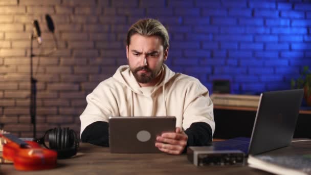 Músico usando tableta en el portátil en el estudio de grabación oscuro — Vídeo de stock