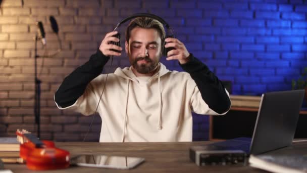 Smiling musician wearing headphones at recording studio — Stock Video