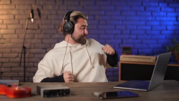 Mand nyder ny sang i hovedtelefoner på lydstudie – Stock-video