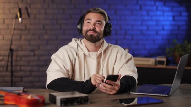 Lykkelig mand ved hjælp af mobil og lytte sang i hovedtelefoner – Stock-video