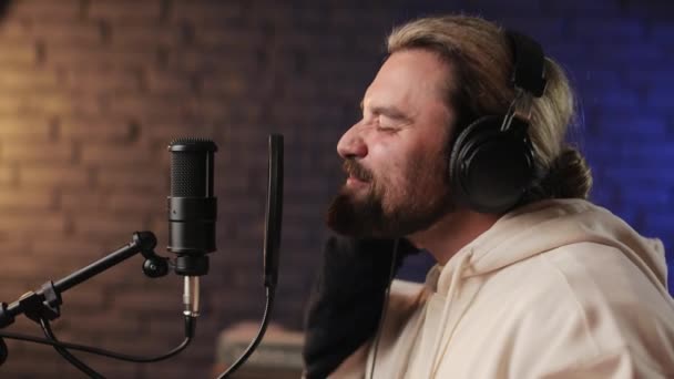 Seitenansicht eines Mannes mit Kopfhörer, der Song im Studio aufnimmt — Stockvideo