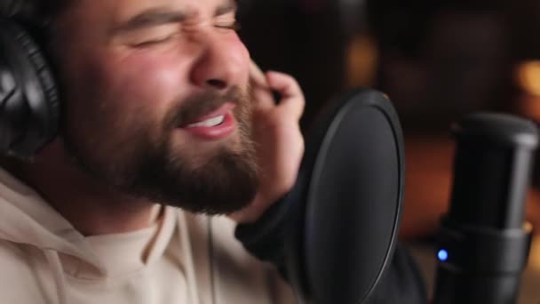 Mand med lukkede øjne synger i mikrofon på studiet – Stock-video