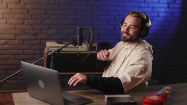 Músico en auriculares usando laptop en estudio de grabación — Vídeos de Stock