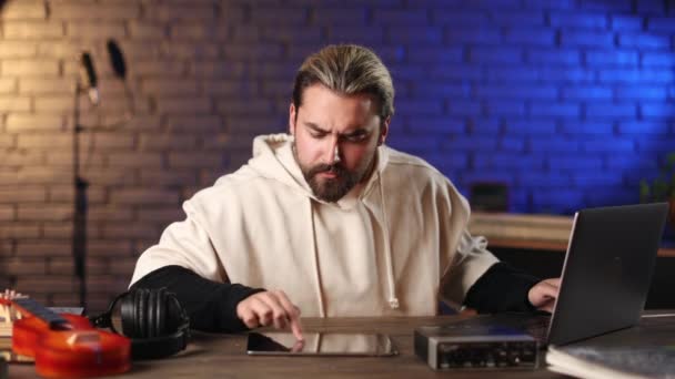 Homem usando laptop e tablet para o trabalho no estúdio de gravação — Vídeo de Stock