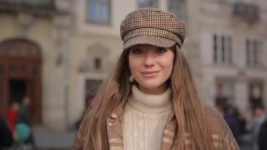 Şık giyinmiş çekici bir kadının portresi açık havada poz veriyor.