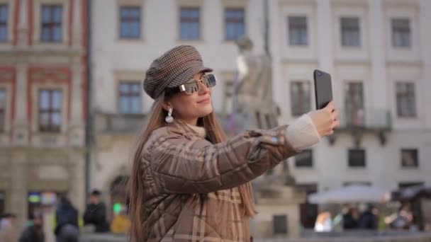 Mujer encantadora tomando selfie en el teléfono inteligente en la calle — Vídeos de Stock