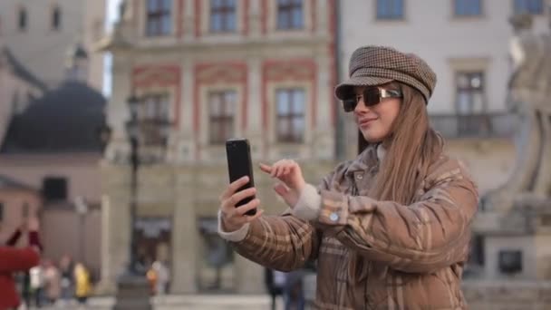 Mujer con estilo usando teléfono inteligente para tomar slefie en la calle — Vídeos de Stock
