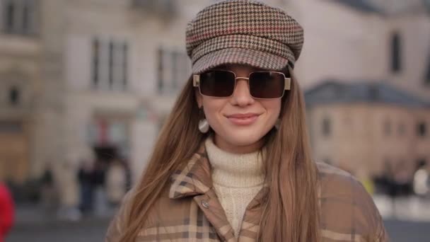 Портрет жінки в модному капелюсі і окулярах позує на відкритому повітрі — стокове відео