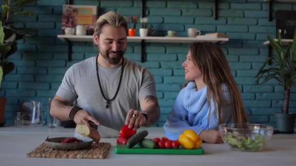 Man and woman preparing fresh salad on modern kitchen — Stock Video