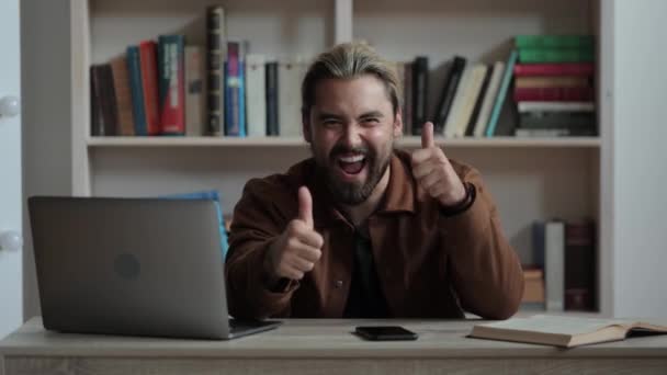 Fyr gesturing tommelfingre op, mens du sidder skrivebord med gadgets – Stock-video