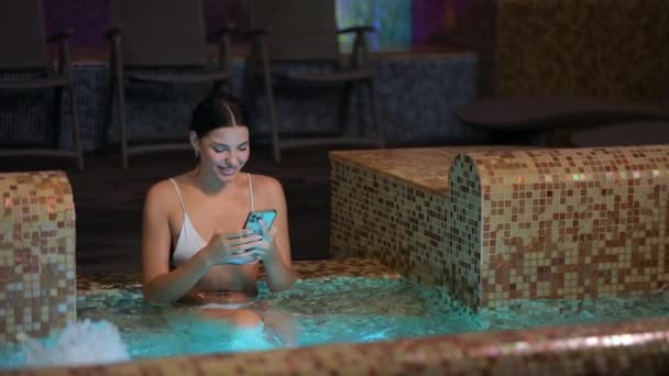 Woman taking selfie on mobile while resting in hot tub — Stock Video