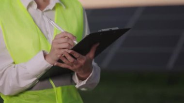 Güneş çiftliğindeki panoya yazı yazan kadını kapat.