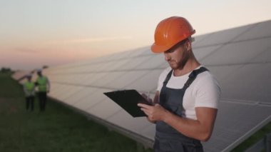 Güneş panelleriyle alan üzerinde çalışan teknisyen ve müfettişler.