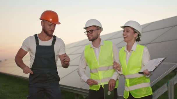 Technician and inspectors dancing and smiling on solar farm. — Stock Video