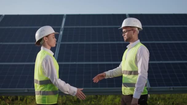 Due colleghi che si stringono la mano in fattoria con pannelli solari. — Video Stock