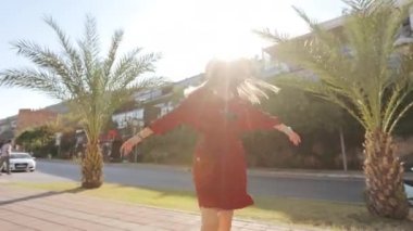 Kasaba sokaklarında yürürken eğlenen bir kadın.