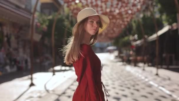 Радісна жінка в літньому вбранні, що ходить по курортному місту — стокове відео