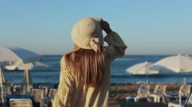 Yaz mevsiminde kadınlar güneşlenmek için deniz kenarında yürürler.