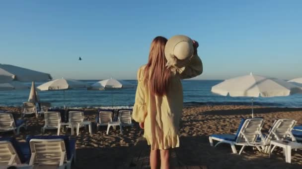 Жінка в літній одяг, що йде серед піщаного пляжу — стокове відео