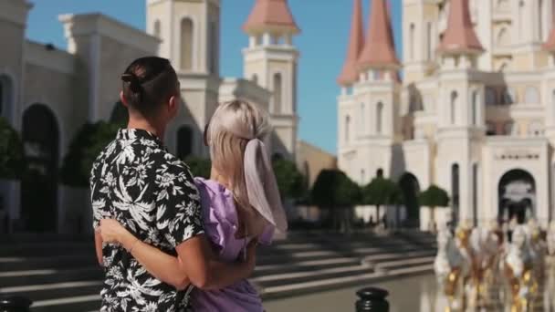 Ευτυχισμένο ζευγάρι στέκεται αγκαλιά ανάμεσα στο πάρκο Land of Legends — Αρχείο Βίντεο