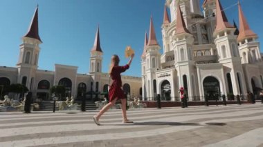 Popüler Türk parkı boyunca yürüyen şapkalı ve elbiseli bir kadın.