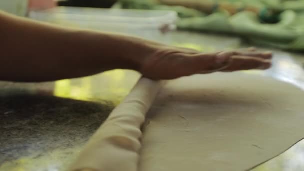 Homme utilisant un rouleau en bois tout en travaillant avec de la pâte crue — Video
