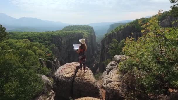 Žena stojící s mapou v rukou na vysokých skalnatých horách — Stock video