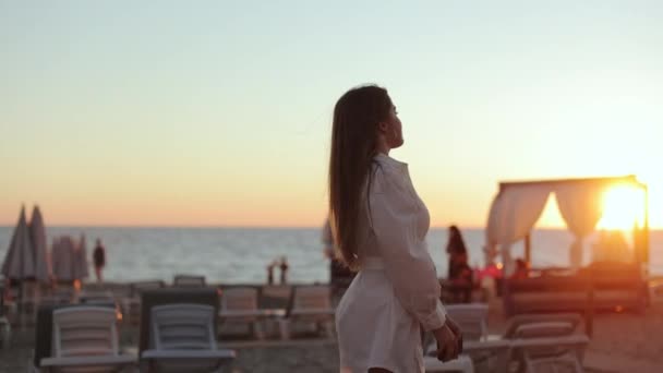 Glad avslappnad kvinna promenader på havet rock under solnedgången — Stockvideo