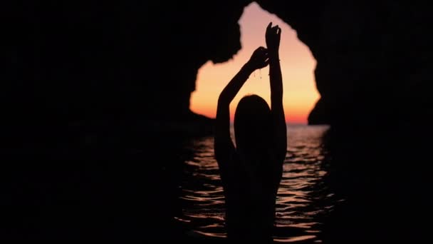 Kvinna i siluett simmar i havet under solnedgången — Stockvideo