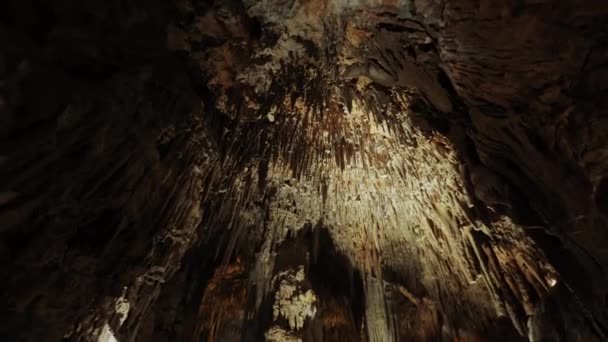 Niedriger Blickwinkel auf dunkle Höhle mit Stalaktiten und Stalagmiten — Stockvideo