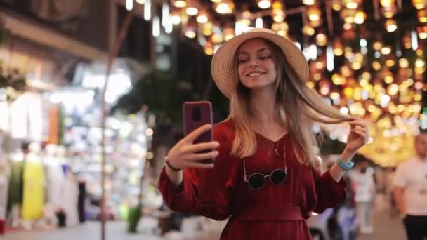 Woman using mobile for taking selfie among city street — Vídeo de stock