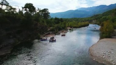 Teknelerde turistlerin rafting yaparken eğlendiklerini gösteren İHA görüntüsü