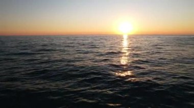 Sakin mavi denizin üzerinde güzel bir yaz günbatımı