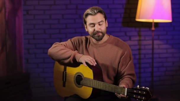 Красивый человек играет на гитаре в студии — стоковое видео