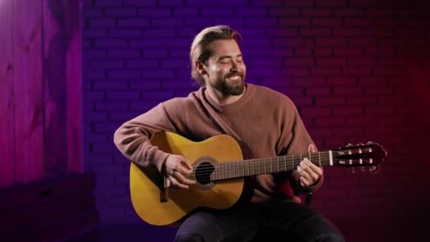 Inspirovaný hudebník sedí ve studiu a hraje na kytaru — Stock video