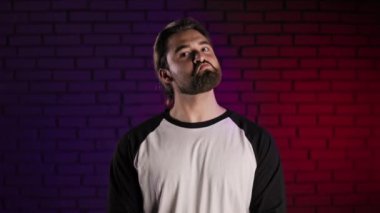 Yakışıklı adam stüdyoda duruyor ve alkışlıyor.