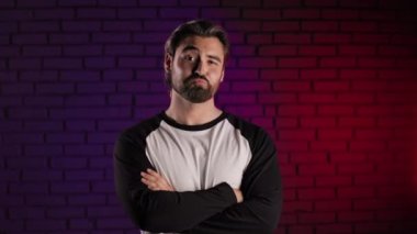 Kendine güvenen adam kollarını kavuşturup başıyla başını sallıyor.