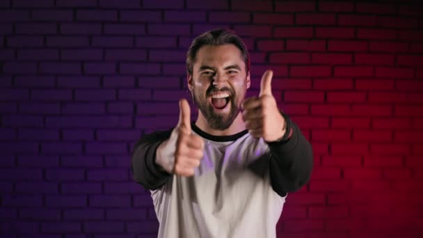 Cheerful man gesturing thumbs up in studio — Stockvideo