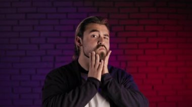 Sakal ve saçlara dokunarak kendine güveni olan yakışıklı bir adam.