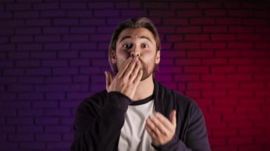 Stüdyoda dikilen ve hava öpücüğü yollayan hoş bir adam.